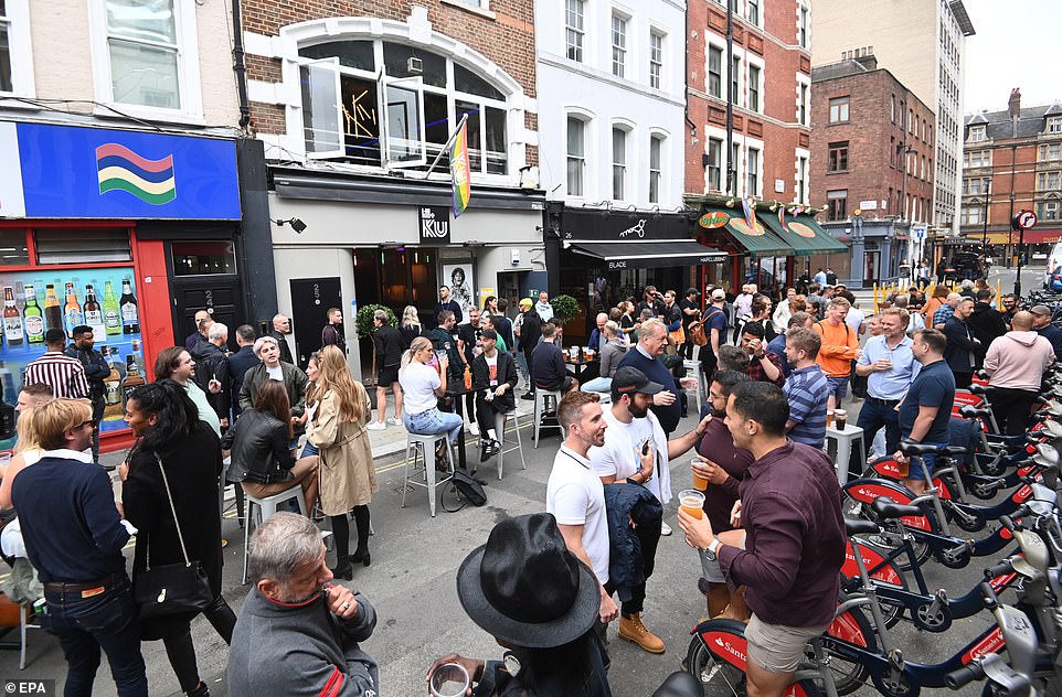 Revellers are pictured in Soho, central London in July last year as pubs, bars and restaurants reopened following the first lockdown